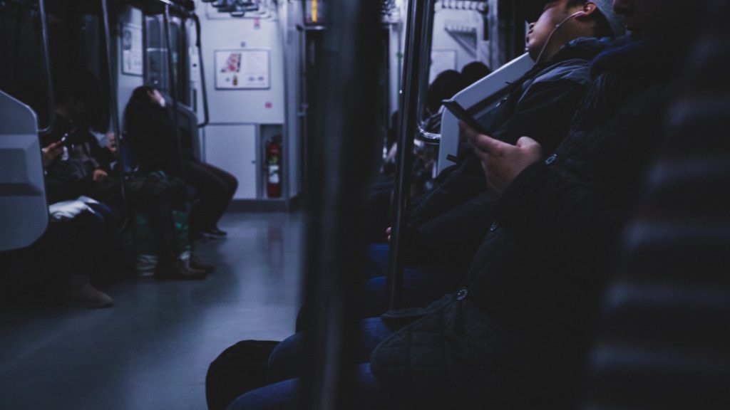 疲れ果てて電車で眠るサラリーマン